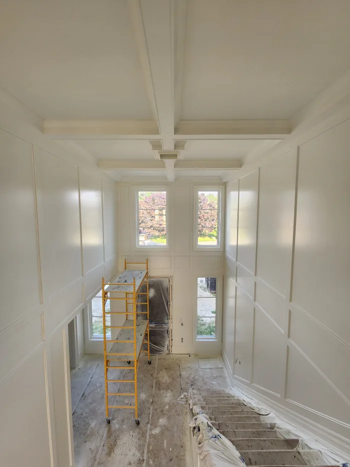 New construction painting by Sigma Painting — full-height wall panelling and coffered ceiling sprayed in off-white